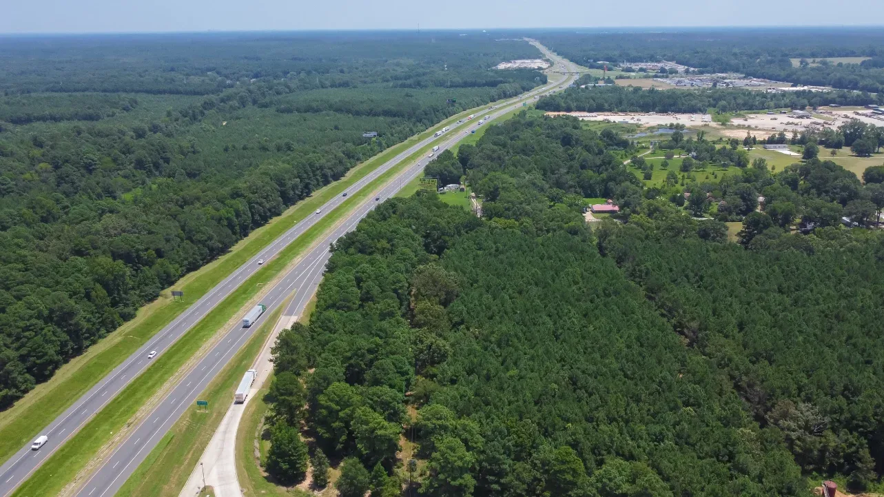 Aerial photo of highway through trees and town